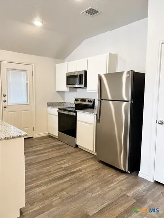a kitchen with stainless steel appliances a refrigerator stove and microwave