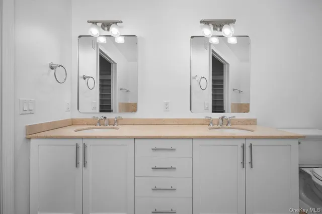 a bathroom with double sink and a mirror