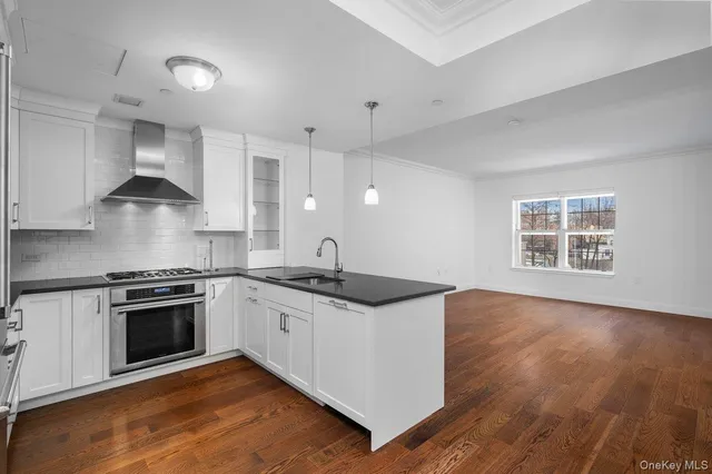 a kitchen with granite countertop a stove and a wooden floors