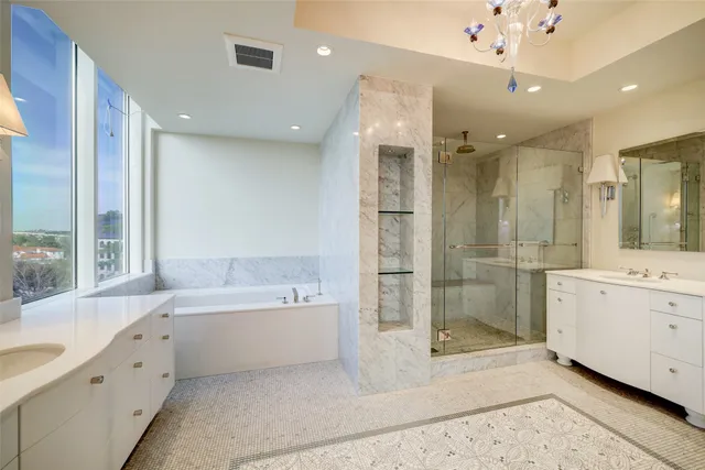 a bathroom with a tub a sink shower and mirror
