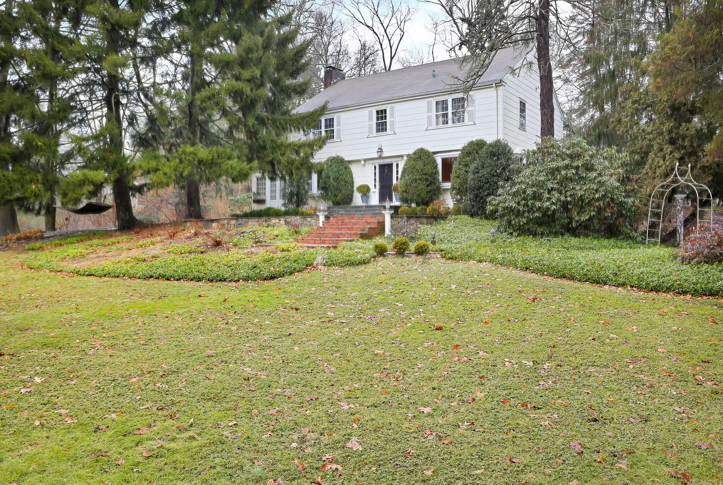 65 Nursery Road New Canaan, CT 06840 - Photo 34 of 37 a view of a white house with a big yard and large trees