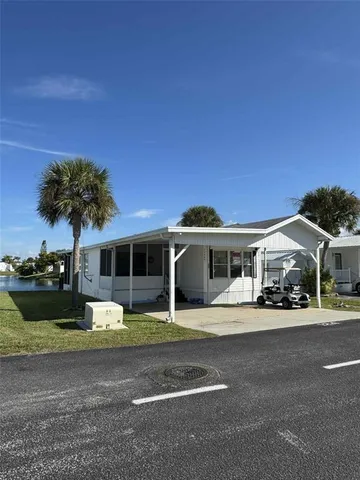 a view of a house with a big yard and large trees
