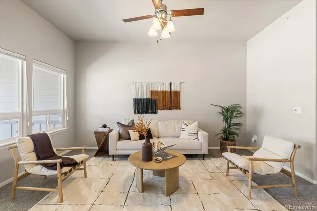 a living room with fireplace furniture and floor to ceiling windows