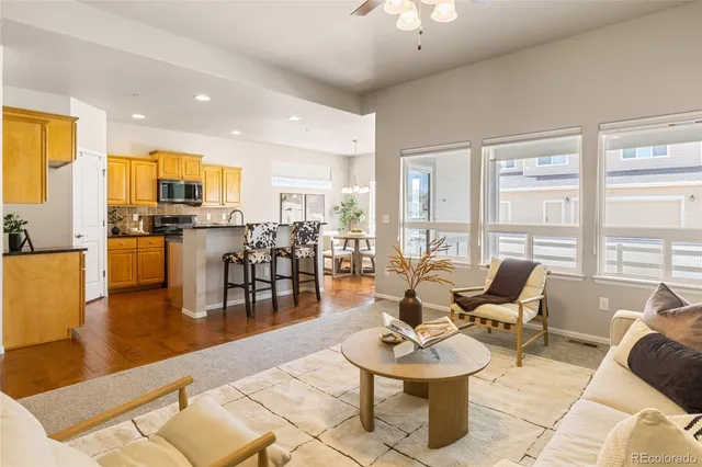 a living room with furniture kitchen view and a large window
