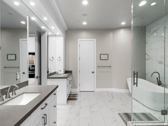614 East High Lane Alpine, UT 84004 - Photo 41 of 75 Bathroom with a freestanding bath, recessed lighting, light marble finish flooring, and two vanities