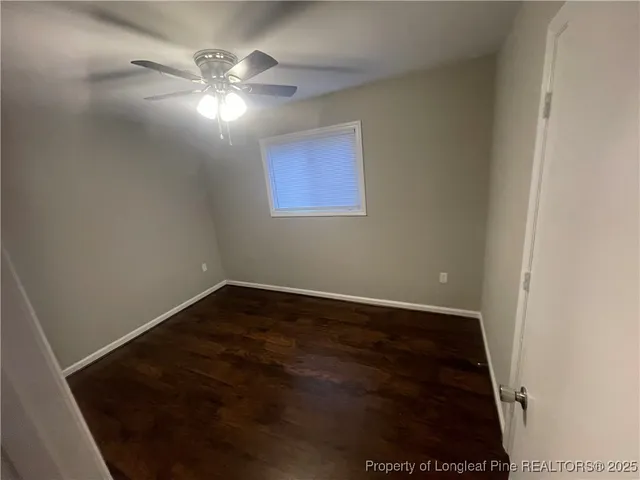 a view of an empty room with a chandelier fan