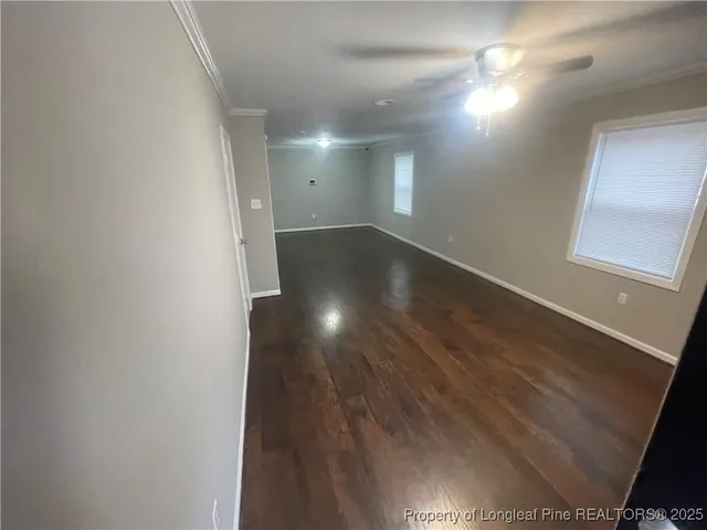a view of empty room with wooden floor