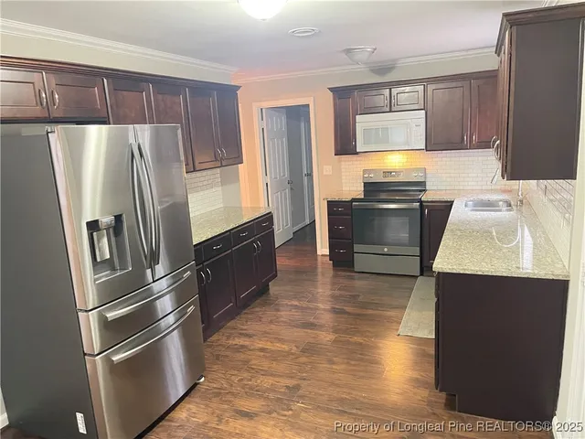 a kitchen with granite countertop a refrigerator and a sink