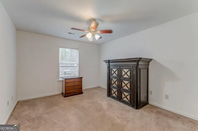 an empty room with windows and ceiling fan