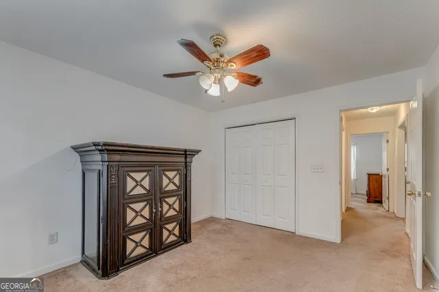 an empty room with windows and fan
