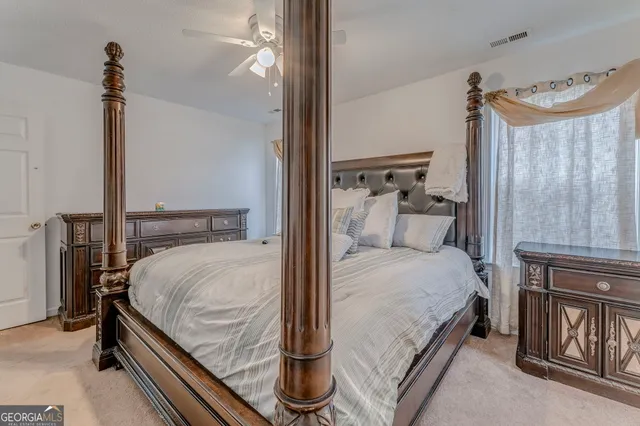 a bedroom with a large bed and a chandelier