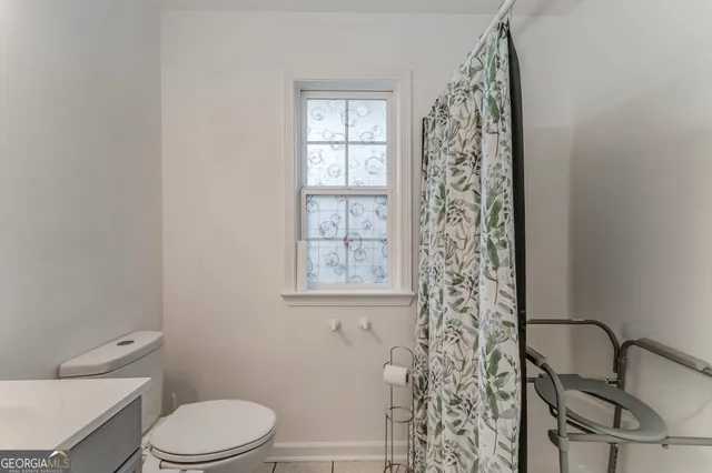 a bathroom with a toilet a sink and a window