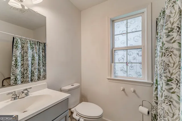 a bathroom with a sink toilet and window