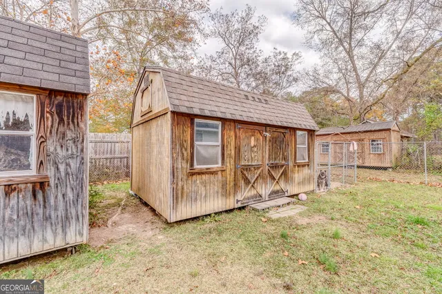 a view of a house with a yard and wooden fence