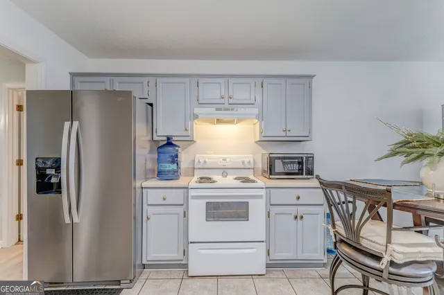 a kitchen with a stove refrigerator and cabinets
