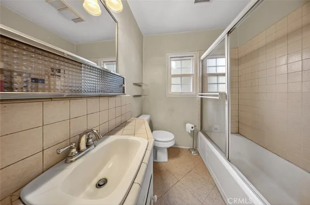a bathroom with a sink and mirror with toilet