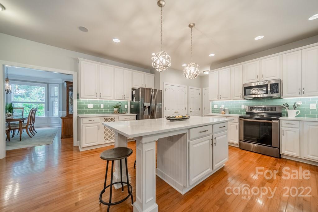 9622 Baileywick Road Charlotte, NC 28277 - Photo 11 of 39 a kitchen with kitchen island granite countertop a stove a sink a center island and cabinets