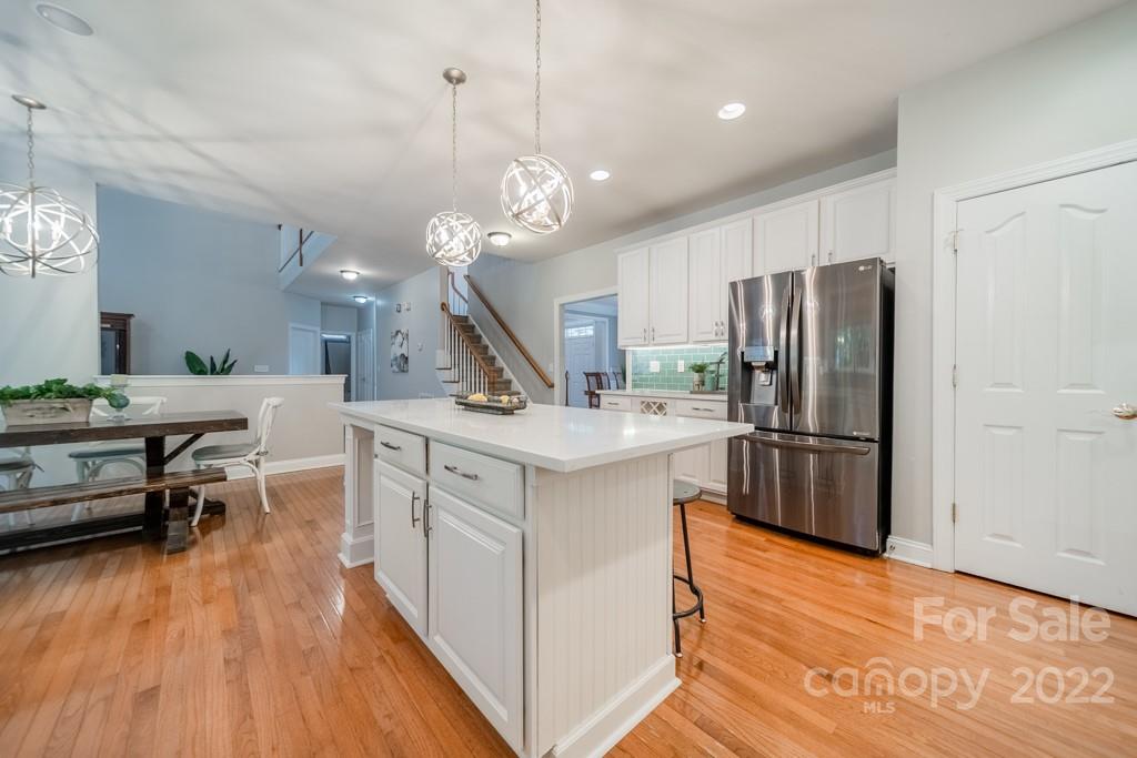 9622 Baileywick Road Charlotte, NC 28277 - Photo 12 of 39 a kitchen with stainless steel appliances granite countertop a refrigerator a sink dishwasher a stove and a dining table with wooden floor