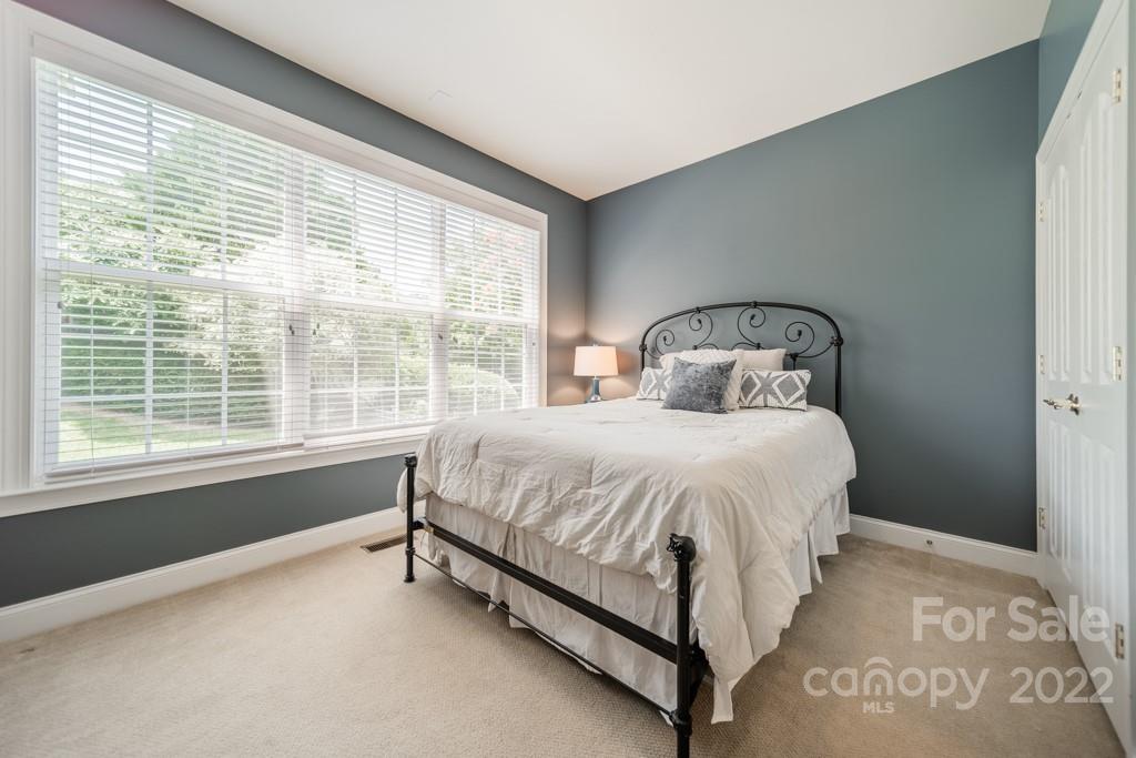 9622 Baileywick Road Charlotte, NC 28277 - Photo 20 of 39 a bed sitting in a bedroom next to a window