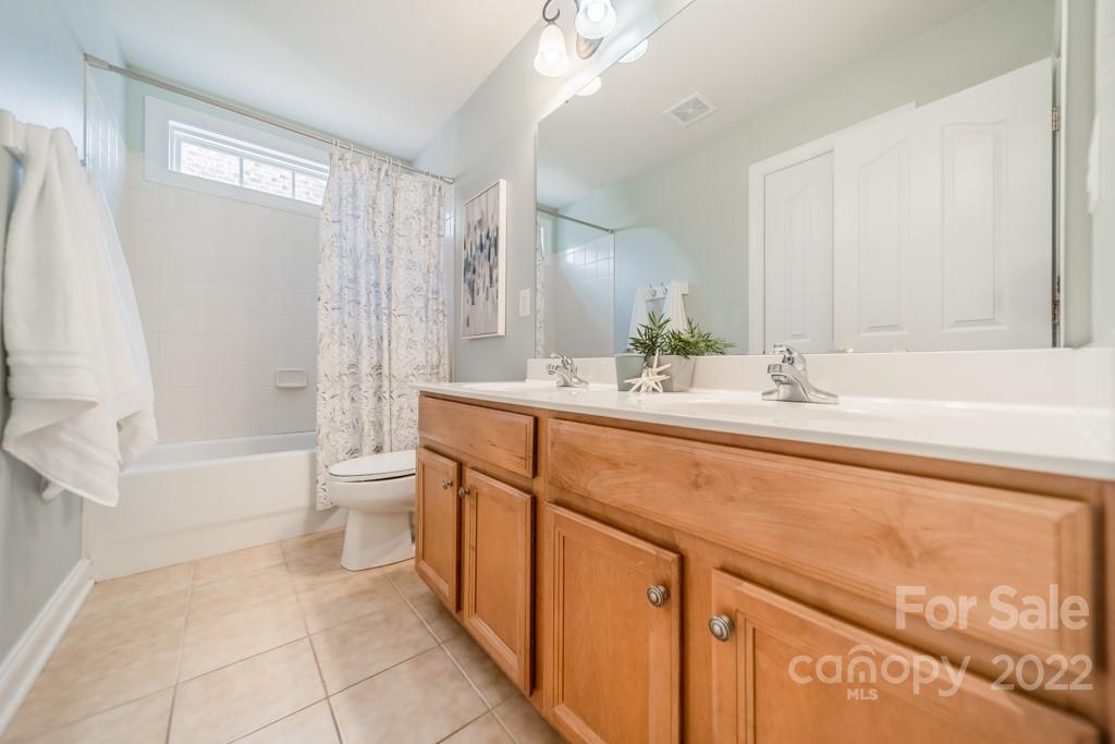 9622 Baileywick Road Charlotte, NC 28277 - Photo 23 of 39 a bathroom with a sink a toilet a mirror and bathtub