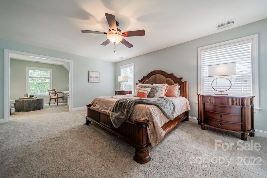 9622 Baileywick Road Charlotte, NC 28277 - Photo 26 of 39 a bedroom with a bed a chandelier and dresser