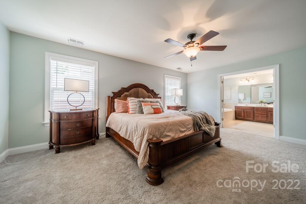 9622 Baileywick Road Charlotte, NC 28277 - Photo 27 of 39 a bedroom with a large bed and a chandelier