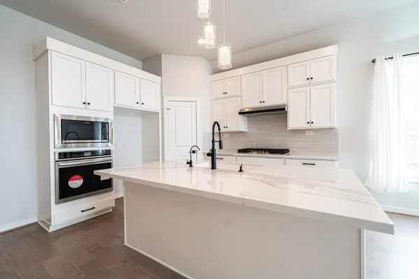 a kitchen with kitchen island a sink stainless steel appliances and cabinets