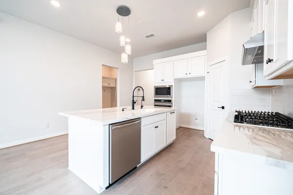 a kitchen with kitchen island a sink appliances and cabinets