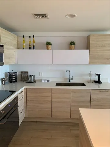 a kitchen with cabinets appliances and a sink