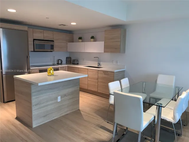 a dining room with furniture and a floor to ceiling window