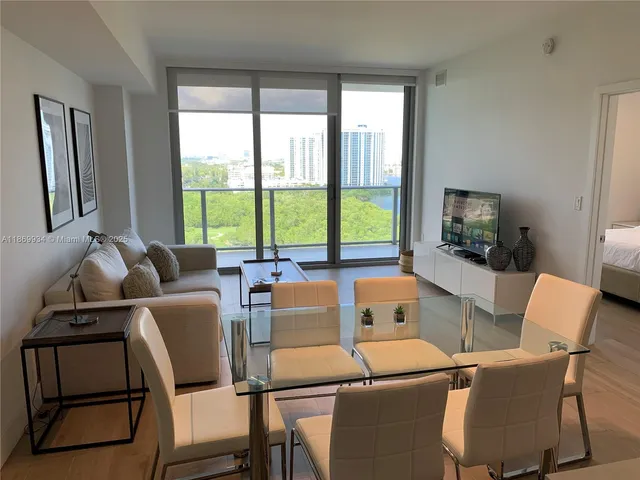 a living room with furniture and a floor to ceiling window