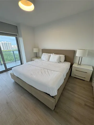 a bedroom with a bed and large window