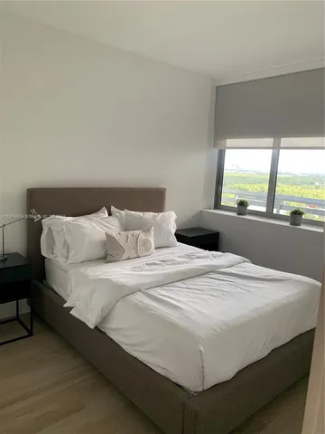 a large bed sitting in a bedroom next to a window