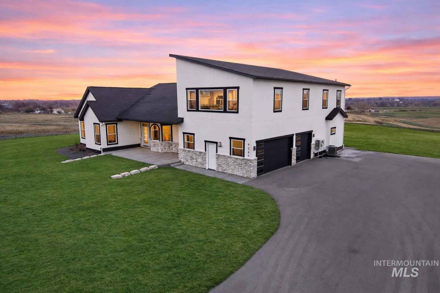 9264 Basin Kid Court Middleton, ID 83644 - Photo 1 of 50 View of front facade with stucco siding, a front lawn, a shingled roof, stone siding, and an attached garage