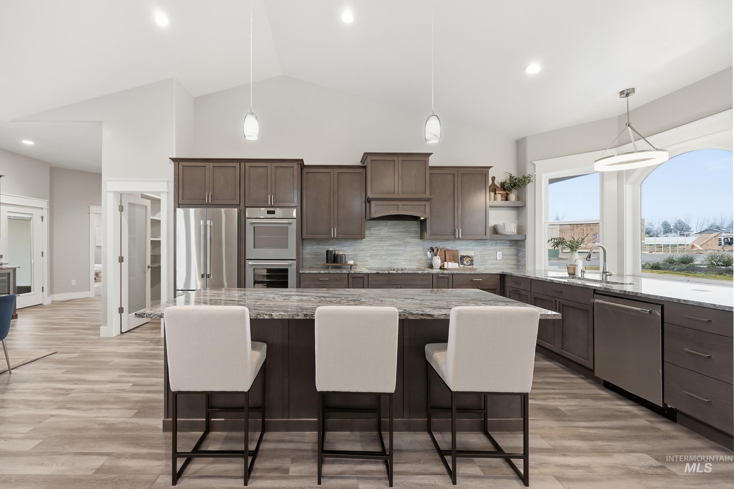 9264 Basin Kid Court Middleton, ID 83644 - Photo 18 of 50 Kitchen featuring pendant lighting, dark brown cabinets, stainless steel appliances, a breakfast bar area, and recessed lighting