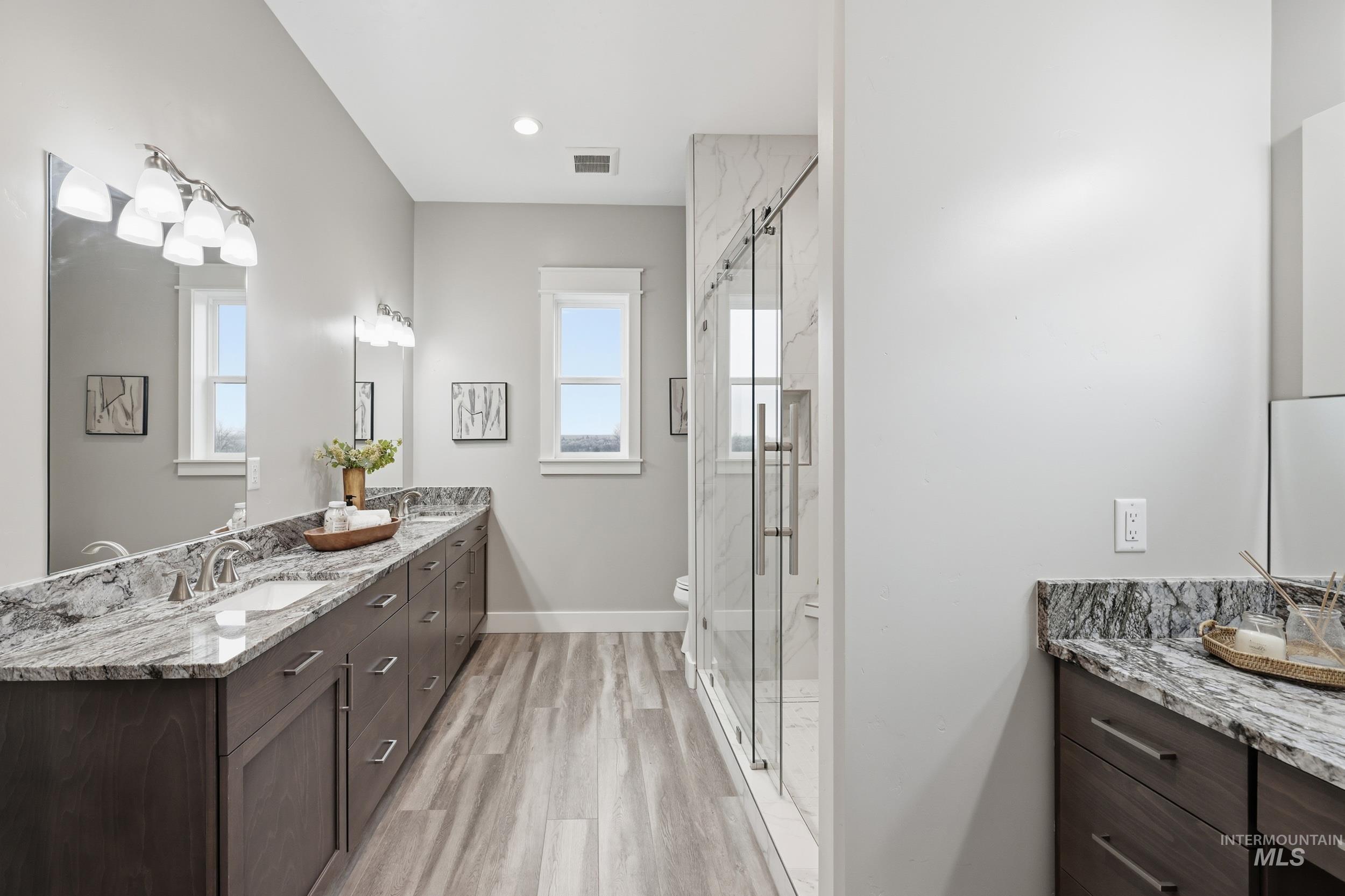 9264 Basin Kid Court Middleton, ID 83644 - Photo 26 of 50 Bathroom featuring double vanity, a marble finish shower, light wood-type flooring, and recessed lighting