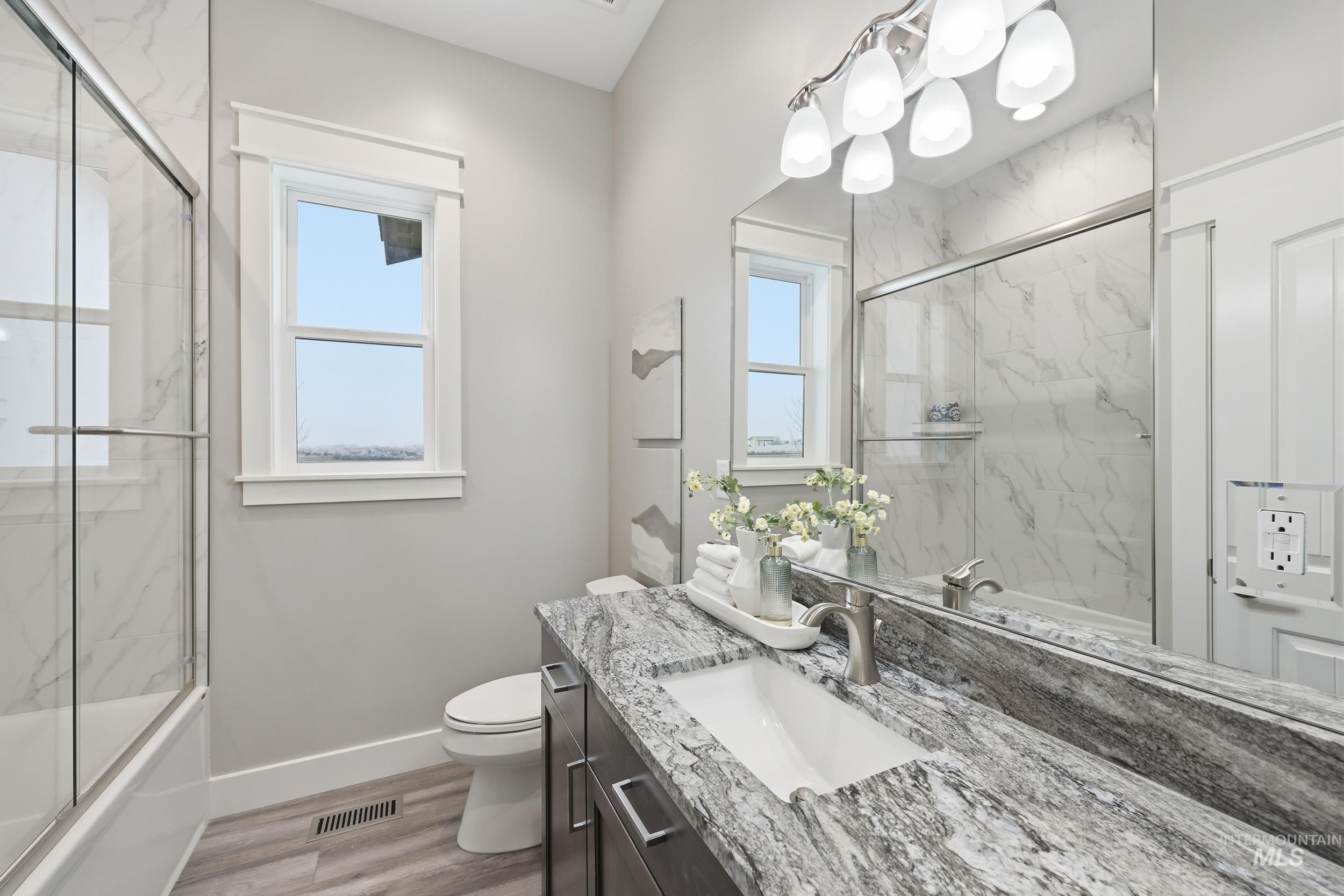 9264 Basin Kid Court Middleton, ID 83644 - Photo 30 of 50 Full bathroom with vanity, light wood-style floors, and combined bath / shower with glass door
