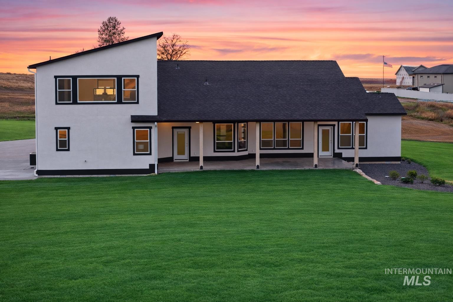 9264 Basin Kid Court Middleton, ID 83644 - Photo 48 of 50 Back of house featuring a yard, a patio, roof with shingles, and stucco siding