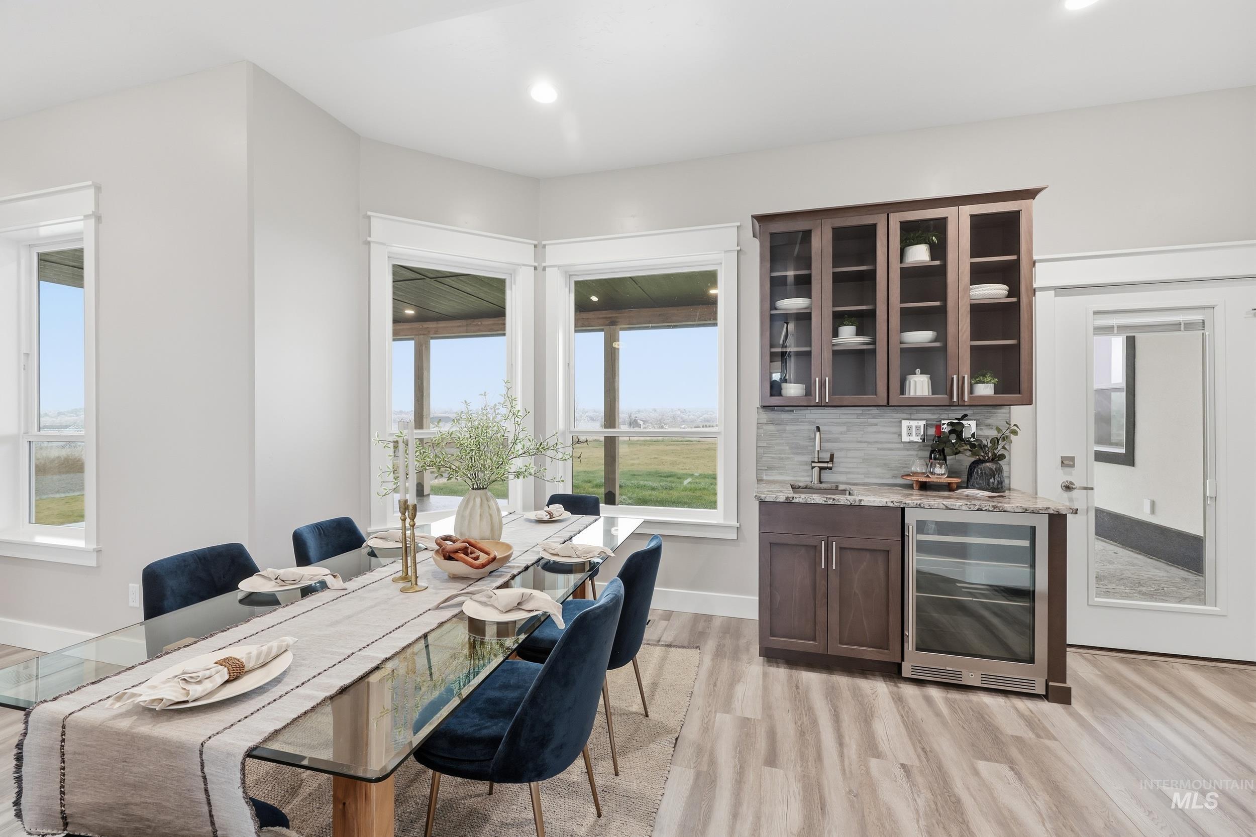 9264 Basin Kid Court Middleton, ID 83644 - Photo 9 of 50 Dining space featuring wine cooler, plenty of natural light, light wood finished floors, bar with sink, and recessed lighting