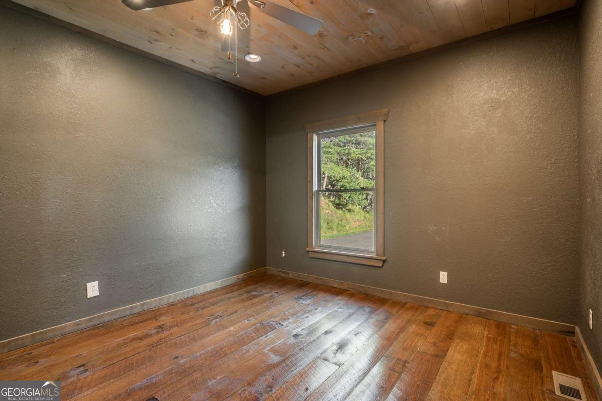 2637 River Road Mineral Bluff, GA 30559 - Photo 19 of 69 an empty room with wooden floor and windows