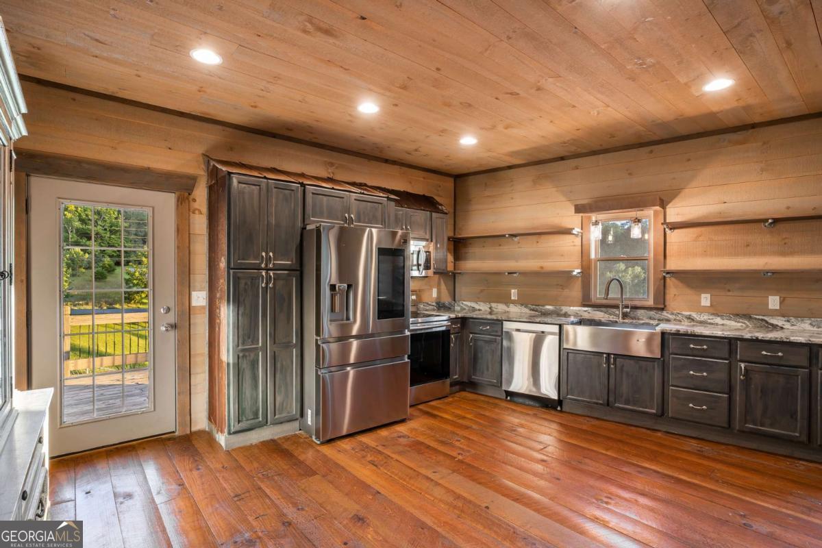 2637 River Road Mineral Bluff, GA 30559 - Photo 9 of 69 a kitchen with stainless steel appliances granite countertop a refrigerator a sink dishwasher a stove and a large countertops with wooden floor