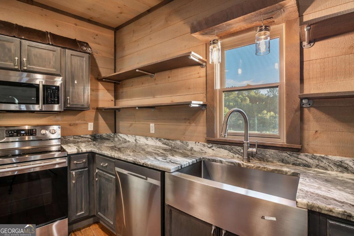 2637 River Road Mineral Bluff, GA 30559 - Photo 10 of 69 a kitchen with stainless steel appliances granite countertop a sink a stove and a microwave oven
