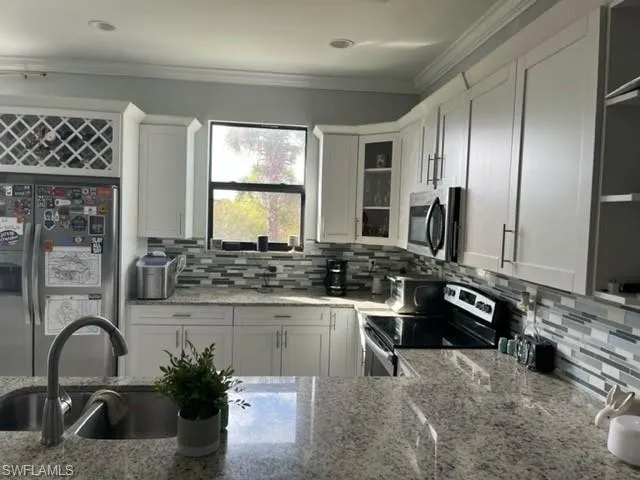 a kitchen with a sink and stainless steel appliances