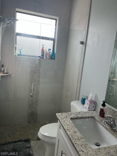 2930 37th Avenue Northeast Naples, FL 34120 - Photo 6 of 8 a bathroom with a granite countertop sink a toilet and a mirror