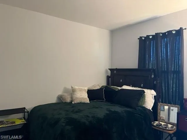 a bed sitting in a bedroom next to a wooden cabinet