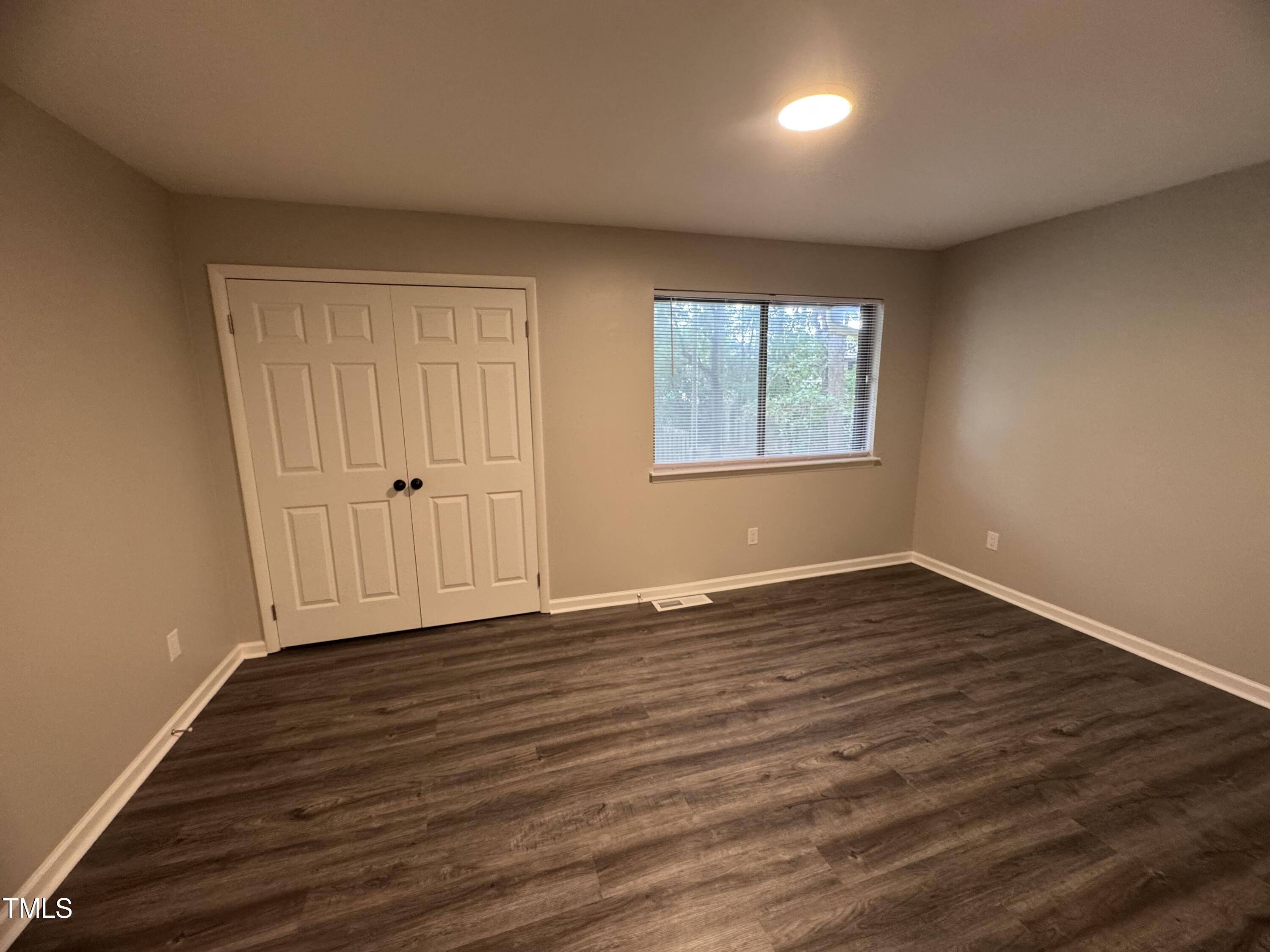 1222 Teakwood Place Raleigh, NC 27606 - Photo 11 of 15 an empty room with wooden floor and windows