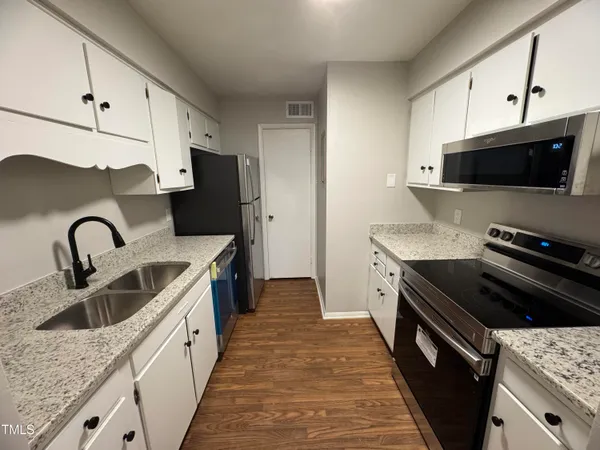 a kitchen with granite countertop a sink and a stove top oven