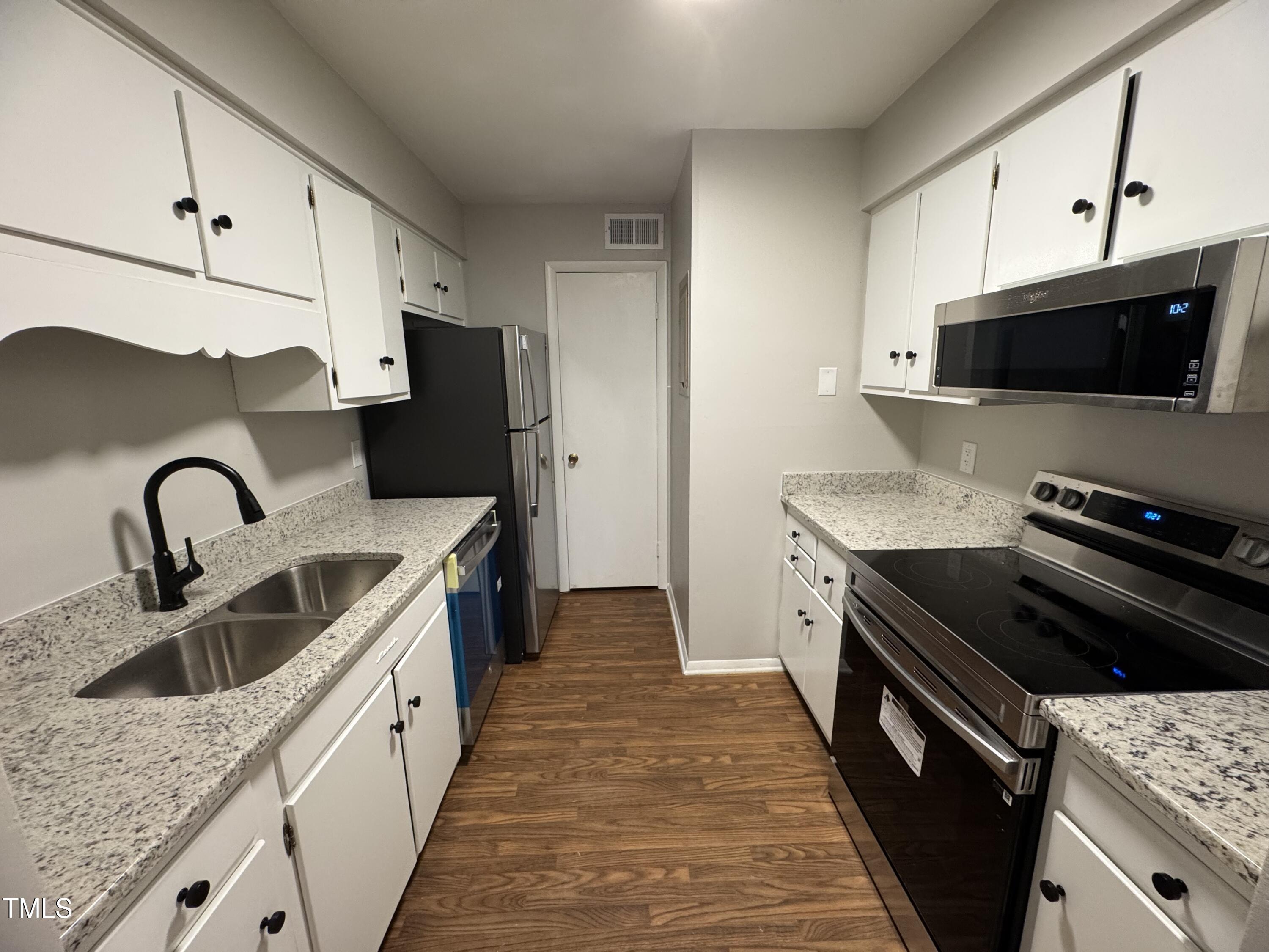 1222 Teakwood Place Raleigh, NC 27606 - Photo 2 of 15 a kitchen with granite countertop a sink and a stove top oven