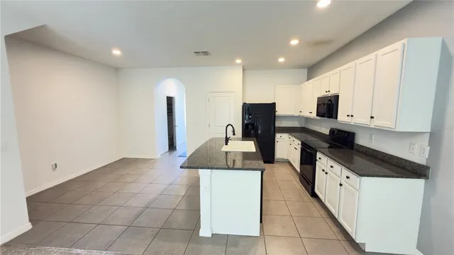 a kitchen with a sink a counter top space appliances and cabinets