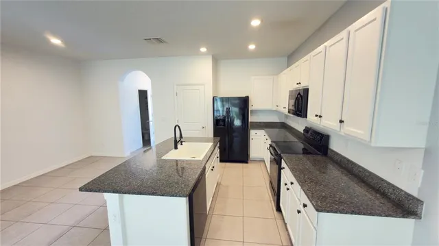 a large kitchen with stainless steel appliances granite countertop a sink and a stove